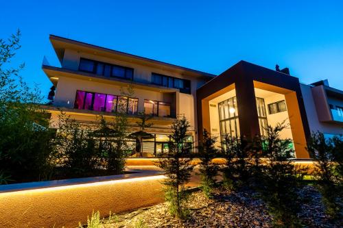 a house with a lit up facade at night at Allure Healthy Hotel & Spa in Eger