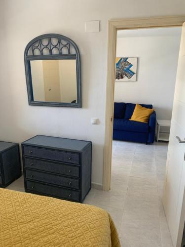 Schlafzimmer mit einem Bett, einer Kommode und einem Spiegel in der Unterkunft Turquesa beach in Calpe
