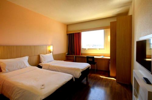 Ένα ή περισσότερα κρεβάτια σε δωμάτιο στο ibis Vitoria Praia do Canto