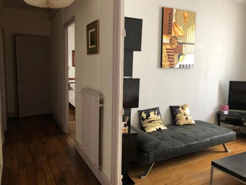 a living room with a couch and a television at Le Campus Victoria I - Train Station & Isabey St - 70m2 in Nancy