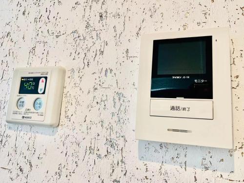 a electronic device with a clock on a wall at TIME SHARING STAY Ikebukuro in Tokyo
