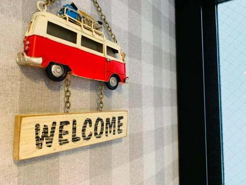 a small red van on a chain with a welcome sign at TIME SHARING STAY Ikebukuro in Tokyo