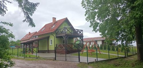 a green house with a playground in front of it at Zielona Ostoja in Ryn