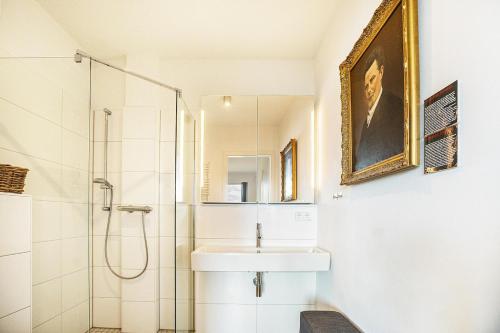 a white bathroom with a sink and a shower at Weserloft 16 in Bremen