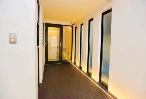 an empty corridor of a building with windows at TIME SHARING STAY Ikebukuro in Tokyo