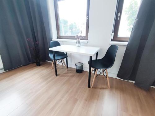 a white table and two chairs in a room at ALFA Stuttgart City 4ZW Beste City Lage Berliner Platz max 8 Personen Netflix Küche WM l 4BR 7 Beds 8 people l Fully equipped Kitchen & Bathroom in Stuttgart