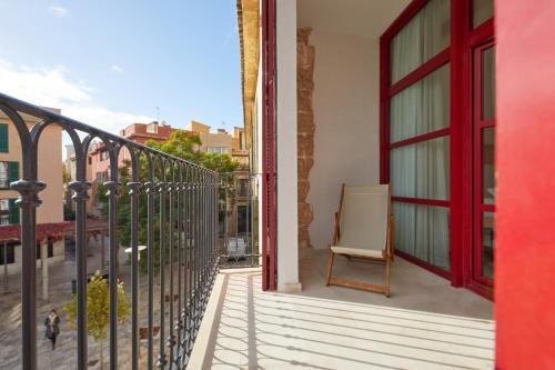 a chair sits on the balcony of a building at Fil Suites in Palma de Mallorca