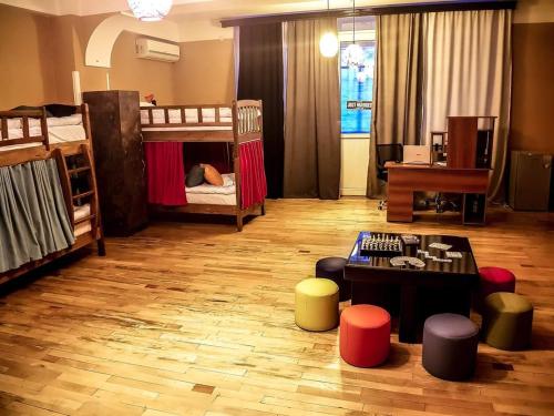 Museum Hostel في تبليسي: غرفة معيشة مع سريرين بطابقين وطاولة