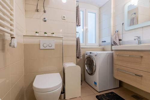 ein Badezimmer mit einem WC und einer Waschmaschine in der Unterkunft Apartman Kortil in Rijeka