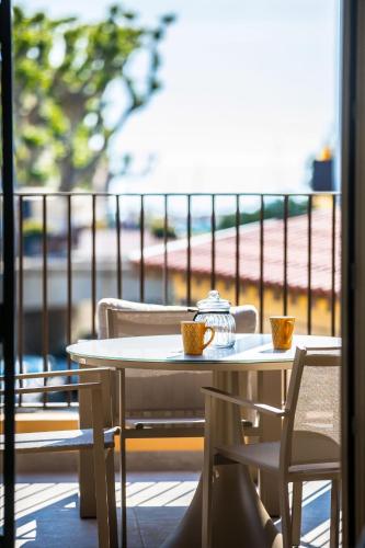 - une table et des chaises sur un balcon avec deux tasses dans l'établissement La Casa Machado 1, à Collioure