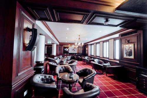 a bar with leather chairs and tables in a room at Steigenberger Cecil Hotel Alexandria in Alexandria