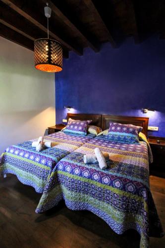 a blue bedroom with a bed with pillows on it at Casa Clarita in Caño