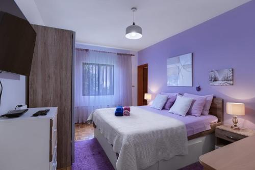 um quarto com uma cama grande e lençóis brancos em Apartman Grošić em Brna