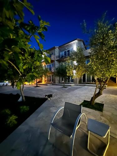 two chairs in front of a building at night at Apartments Edera in Tivat