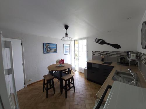 eine Küche mit einem Tisch und Stühlen im Zimmer in der Unterkunft Le Mas d'Evlie in Aubin