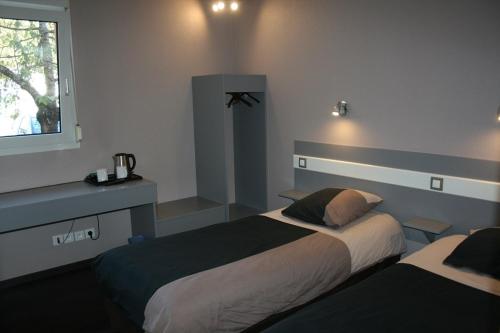 a bedroom with two beds and a window at Kyriad Direct Lure in Lure
