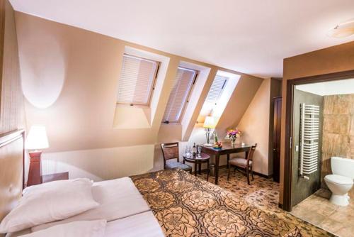 een slaapkamer met een bed en een bureau en een badkamer bij Great Polonia Kraków Kazimierz in Krakau