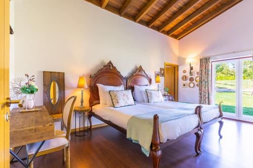 a bedroom with a large bed and a table and a desk at Moinho da Lapa in Lapa