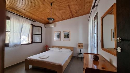 een slaapkamer met een bed en een houten plafond bij Sophia's cottage in Fourka
