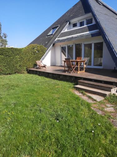 une maison avec une terrasse avec une table et des chaises dans l'établissement Les embruns, à Saint-Philibert