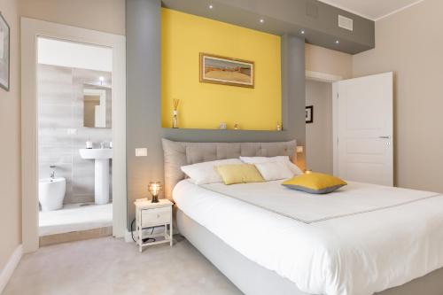 1 Schlafzimmer mit einem großen weißen Bett und einem Badezimmer in der Unterkunft Mirror of the Sea Apartment 5 mt from the beach in Salerno