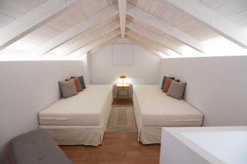 Zimmer im Dachgeschoss mit 2 Betten und einer Lampe in der Unterkunft Dimani Suites in Gythio