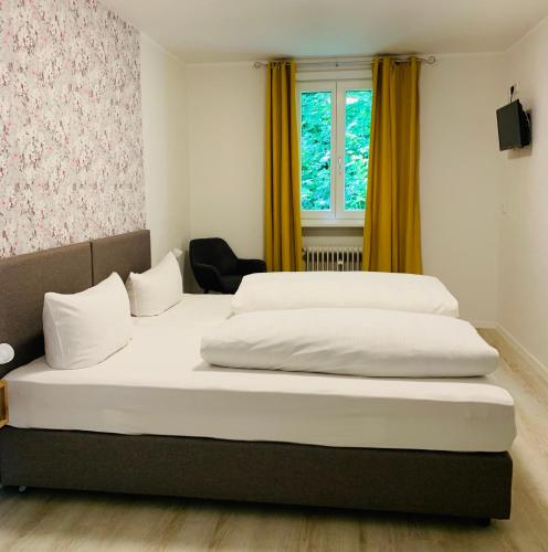 two beds in a room with yellow curtains at Hotel-Restaurant Buger Hof in Bamberg