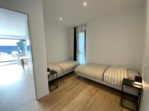 une chambre avec deux lits et un miroir dans l'établissement ARRADON 400m bourg, plages et port, à Arradon