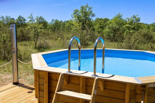 une baignoire en bois avec une chaise près de la piscine dans l'établissement La Terrasse - A Peaceful Place in the Forest, à Concots