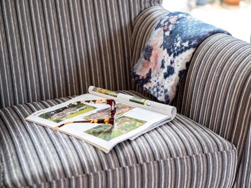 a book on a couch with a magazine on it at Longhouse Bungalow in Polzeath