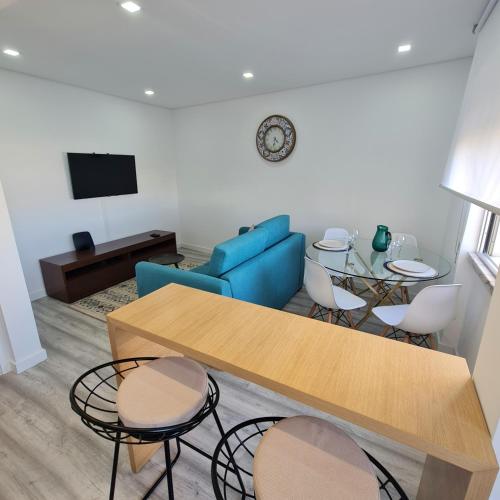 - un salon avec un canapé bleu, une table et des chaises dans l'établissement S. Soares T3 Setúbal, à Setúbal