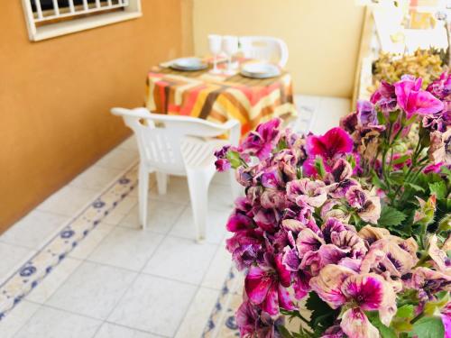 a dining room with a table and purple flowers at Holiday House in Alghero