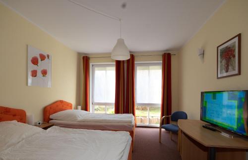 a hotel room with two beds and a flat screen tv at Schwalbenflug 1 Berlin in Berlin
