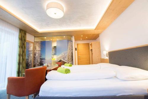 a hotel room with two beds and a desk at Haus Alblitt in Kappl