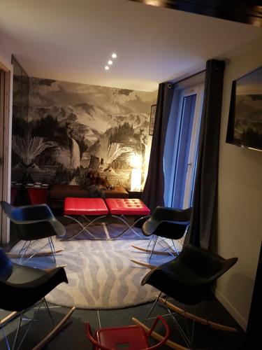 une chambre avec des chaises et un tableau sur le mur dans l'établissement 1+1, à Les Deux Alpes