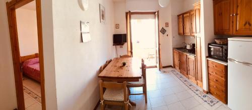 a kitchen with a wooden table and a refrigerator at Holiday House in Alghero