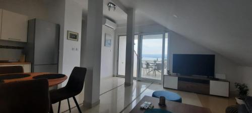 a living room with a television and a table with chairs at Apartment Illyricum in Bol