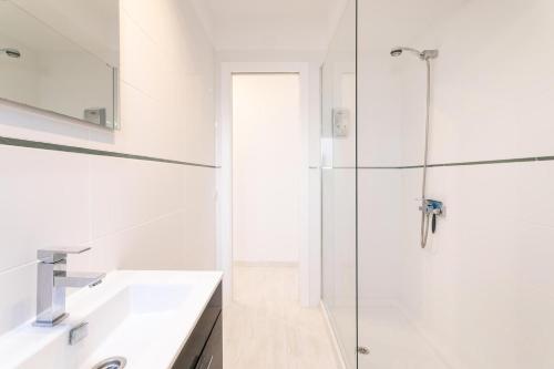 a white bathroom with a shower and a sink at Very nice and modern studio front of the beach in El Campello