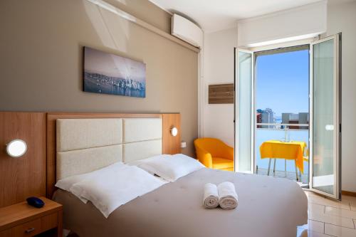 Un dormitorio con una cama con dos zapatos blancos. en Amadei Hotel Figaro & Apartments, en Pesaro
