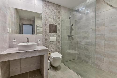 a bathroom with a toilet and a sink and a shower at Hotel Stračena City in Ostrava