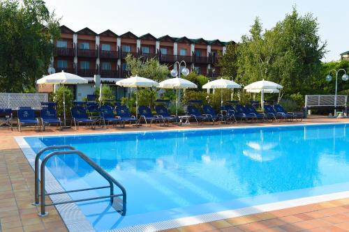 einen Pool mit Stühlen und Sonnenschirmen in einem Hotel in der Unterkunft Residence Il Patio in Iseo