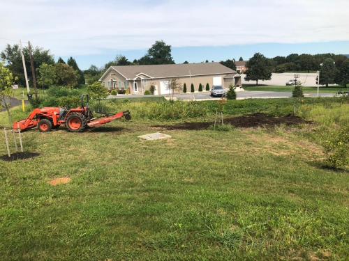 a tractor sitting in a field in front of a house at Microtel Inn & Suites by Wyndham Carlisle in Carlisle