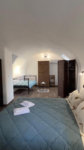 a bedroom with a large blue bed in a room at Nikolas House - ΤΟ ΣΠΙΤΙ ΤΟΥ ΝΙΚΟΛΑ in Archea Pissa