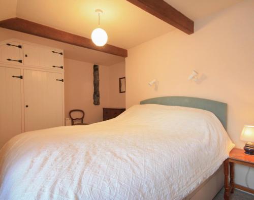 a bedroom with a large white bed and a table at Mill Pond in Saint Minver