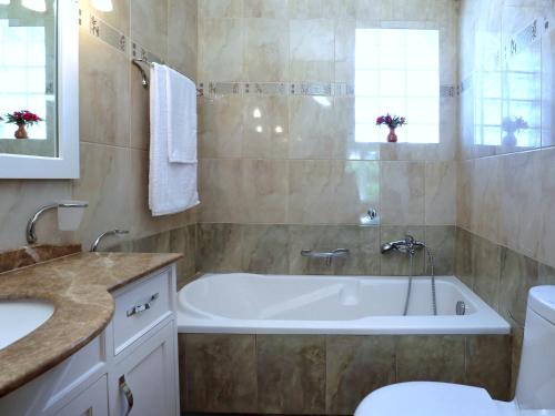 La salle de bains est pourvue d'une baignoire, de toilettes et d'un lavabo. dans l'établissement Gloria's House, à Kariá