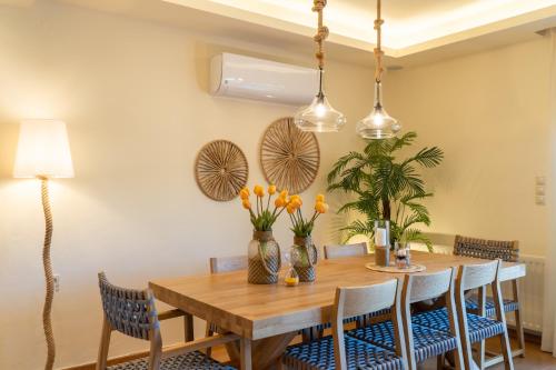 a dining room with a wooden table and chairs at Green Acre Villa in Karteros