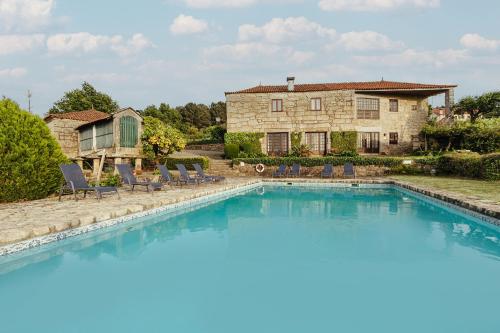 a large swimming pool in front of a house at Quinta de Santo Antonio in Sá