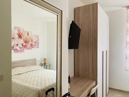 1 dormitorio con espejo, cama y escritorio en La Casa di Chiara, en Porto SantʼElpidio