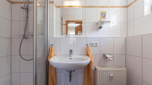 a white bathroom with a sink and a shower at Sonnenhof Hagnau in Hagnau