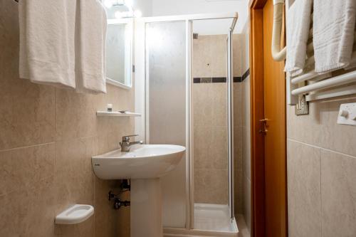 a bathroom with a sink, toilet and shower at Amadei Hotel Figaro & Apartments in Pesaro